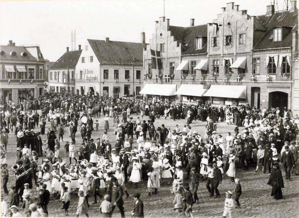 Sønderjysk Forening Billede af den imponerende mængde mennesker på Maribo Torv ved Sønderjydernes besøg 22 til 24.juni 1912. De 100 sønderjyder besøgte sammen med de lokale arrangører bl.a. Borgø og spiste i Aktiehaven.